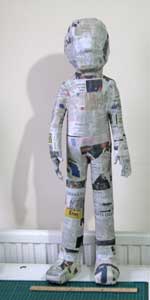 Use masking tape (such as 3M 2cm wide tape) to make the basic figure from paper tubes and crumpled paper Guardsman02.jpg