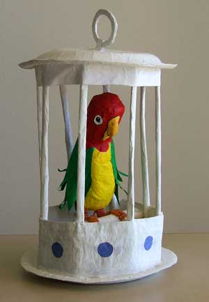Paper parrot in a paper cage Paper parrot in a paper cage
